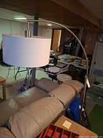 Full view of metal arc floor lamp behind sofa
