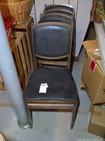 Four stacked wood folding chairs showing overall style and number