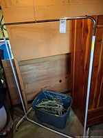 Front view of metal garment rack with tote of hangers