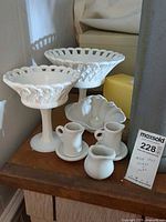 Full lot view showing both milk glass compotes, ruffled bowl, three ceramic creamers and saucer
