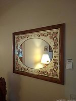 Front view showing mirror, floral border, frame