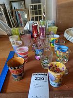 All 21 souvenir shot glasses grouped on shelf