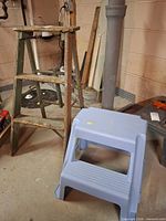 Plastic step stool front and side of wooden ladder