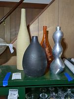 All four vases grouped on shelf
