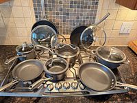 Full set on gas cooktop showing all pans and lids