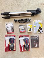 Group view: full-size tripod, mini tripod, two cleaning kits, LCD protector, UV filter, HDMI cable, charger, soft box diffuser