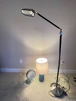 All three items together: adjustable floor lamp, teal table lamp with shade, chrome lighted makeup mirror