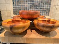 five wooden bowls on cutting board, top view
