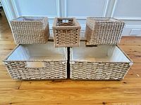 Group view of seven baskets: four large rectangular on bottom, three smaller on top