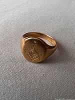 Full view of yellow gold signet ring showing engraved Masonic emblem