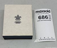 White outer sleeve with Olympic snowflake emblem and lot tag visible