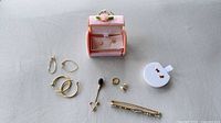 Full assortment laid out including brooch, hoops, flower studs, stick pin, single hoop and pink box