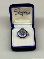 Ring watch in Simpsons box, lid open showing brand logo