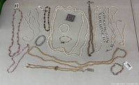 Full layout of all pearl necklaces, bracelets and earrings on table
