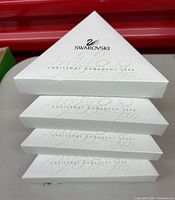 Stacked view of four white triangular Swarovski Christmas Ornament 2000 boxes