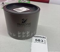 Grey cylindrical Swarovski Silver Crystal box with label and lot tag