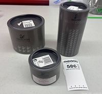 Three cylindrical Swarovski Silver Crystal boxes on table with lot sticker