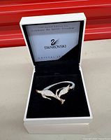 Brooch inside original presentation box showing swan design and lid text referencing 1999 Annual Edition "Freedom"