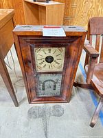 Front view of entire clock showing dial and lower glass panel