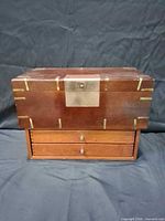 Front view showing writing slope with brass fittings on two-drawer base