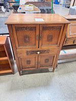 Front view of carved wood cabinet closed