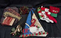 Group shot of all holiday items including tree skirt, garlands, picks, stockings, hat and gnome