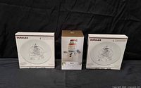 Two boxed Duralex plate sets and central snowman dish set