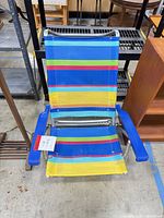 Full view of folding beach chair showing frame, fabric pattern, and armrests
