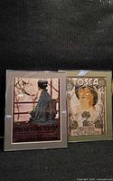 Both framed Puccini posters side by side