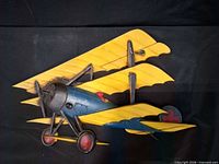 Front view of metal triplane plaque showing overall design and colors