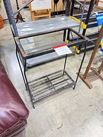 Full view of metal stand showing missing top surface and lower shelf