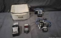 Entire lot: camera bag, flash pouch, flash unit, camera with lens and blue half-case shown