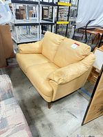 Full view of yellow leather Natuzzi loveseat