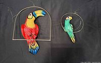 Both parrot decorations side by side showing size comparison and colors