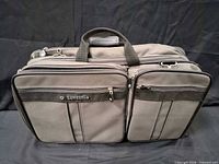 Front view of Samsonite gray travel bag showing brand logo and exterior pockets