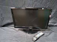 Front view of Samsung 19-inch HDTV on stand with remote and cord