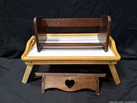 Lap tray with tabletop shelf rack positioned on it and wall shelf in front