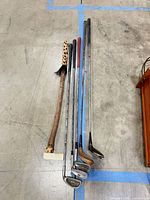 Lot overview of five clubs and walking stick on floor
