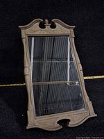 Front view of mirror showing carved frame and glass