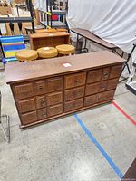 Front view of carved wood dresser showing drawer arrangement and handles