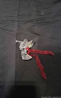 Front view of crystal angel ornament with red ribbon
