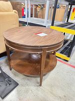 overall view of round wooden side table showing top and shelf