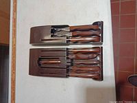 Cutco utensils seated in two brown storage trays