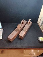 Two wooden hand planes on table