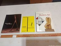 Front covers of all three books with ruler for scale