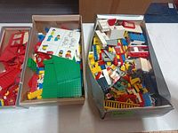 Three boxes filled with assorted LEGO pieces of various colours and types