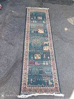 Full view of runner rug laid flat showing design, border and fringe