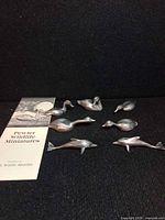Seven pewter miniatures with pamphlet showing brand and series