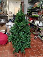 Full view of artificial Christmas tree with lights and stand