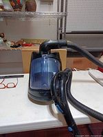 Top view of Fantom Lightning canister vacuum showing hose, handle, control buttons and translucent dust bin